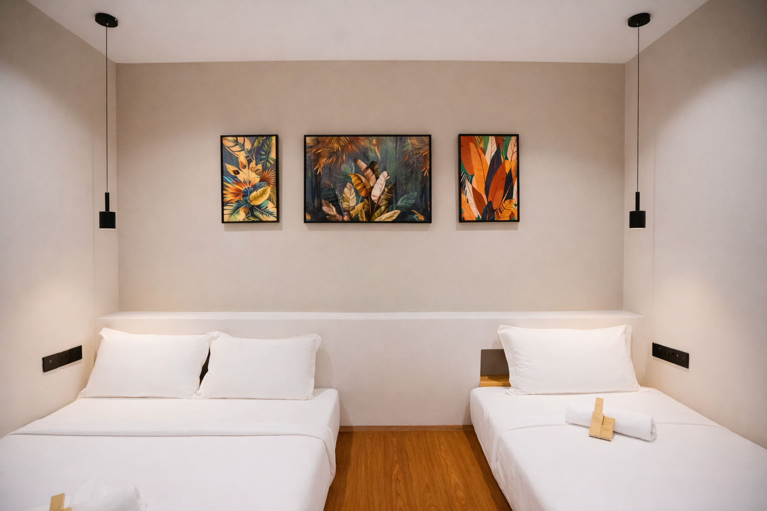 A queen bed and a single bed with a towel and amenities pack.